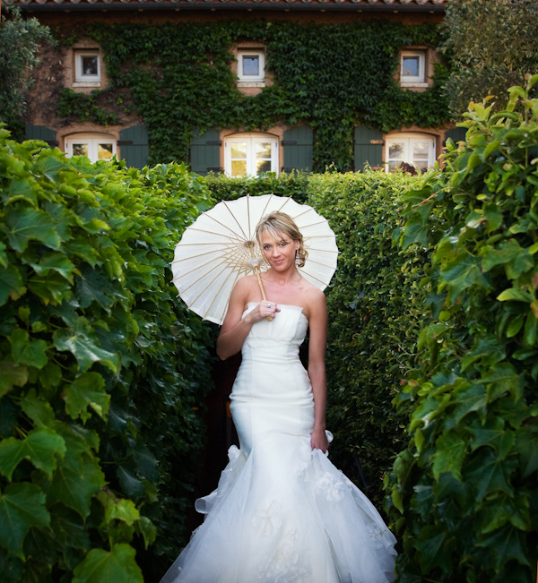 bride with parasol in garden wedding photo by Catherine Hall Studios